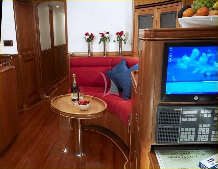 a living room with a television and a table aboard DARK STAR OF LONDON Yacht for Charter