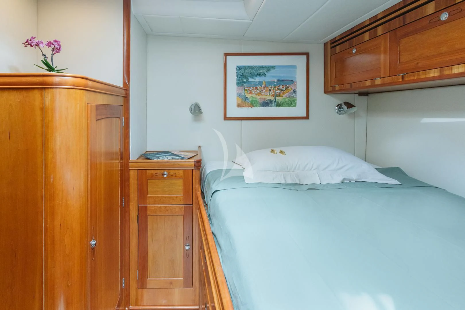 a bed with a white pillow aboard DARK STAR OF LONDON Yacht for Charter