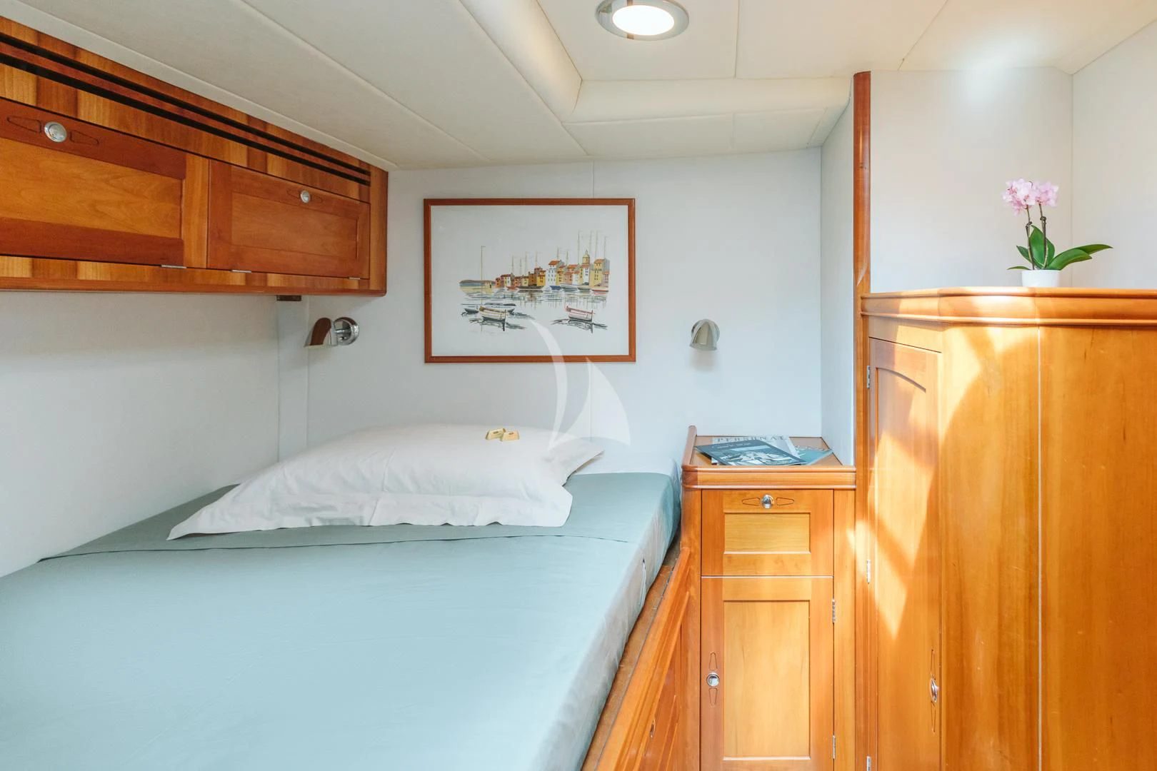 a bedroom with a bed and a dresser aboard DARK STAR OF LONDON Yacht for Charter