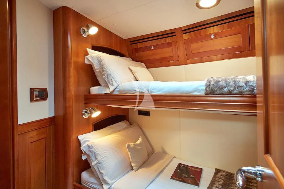 a bed with a wooden headboard aboard DARK STAR OF LONDON Yacht for Charter