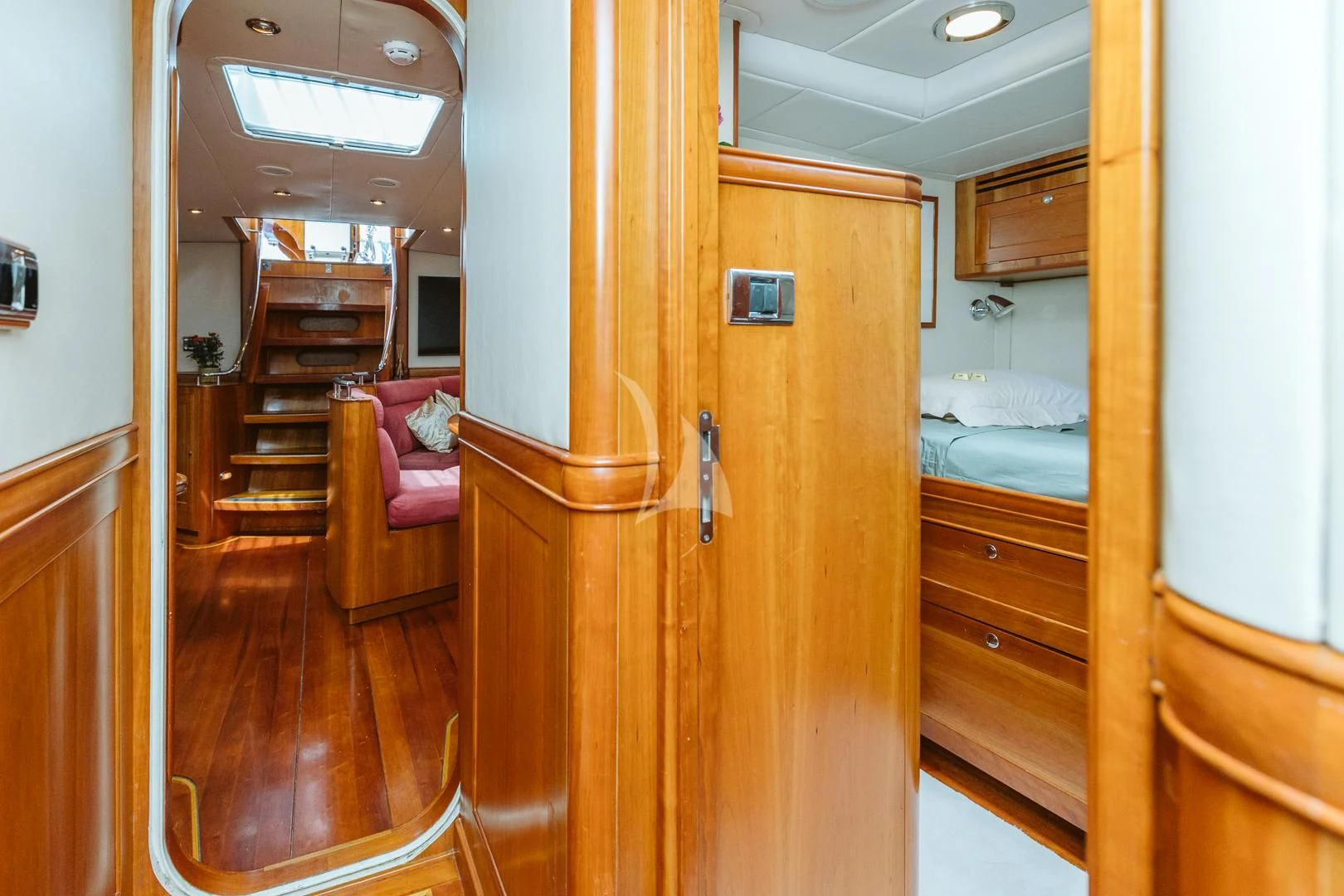 a room with a wood door and a bed in it aboard DARK STAR OF LONDON Yacht for Charter