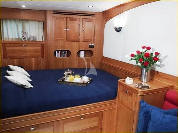 a room with a bed and a table with food on it aboard DARK STAR OF LONDON Yacht for Charter