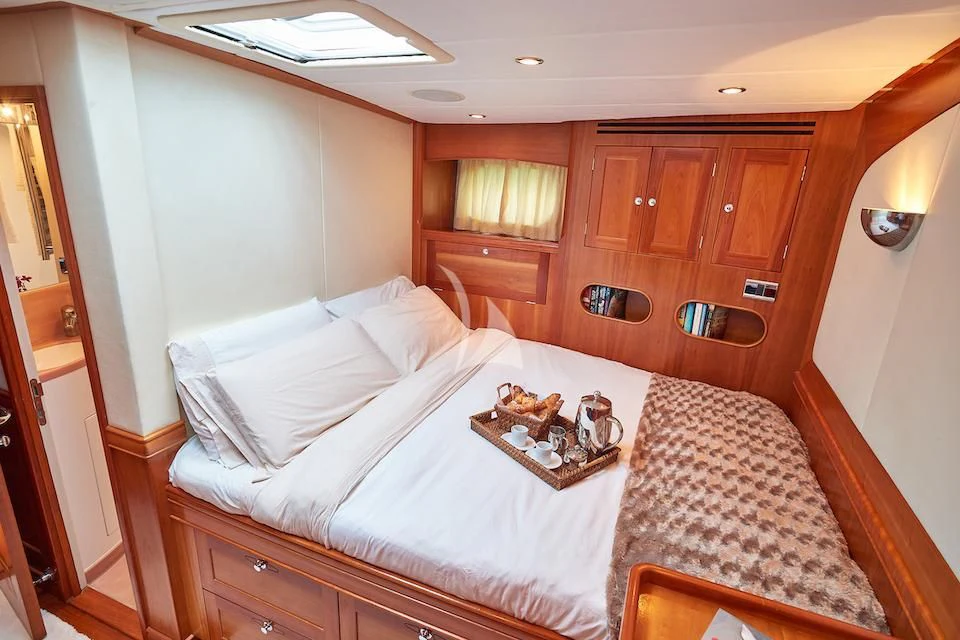 a bed with a white sheet and a tray on it aboard DARK STAR OF LONDON Yacht for Charter