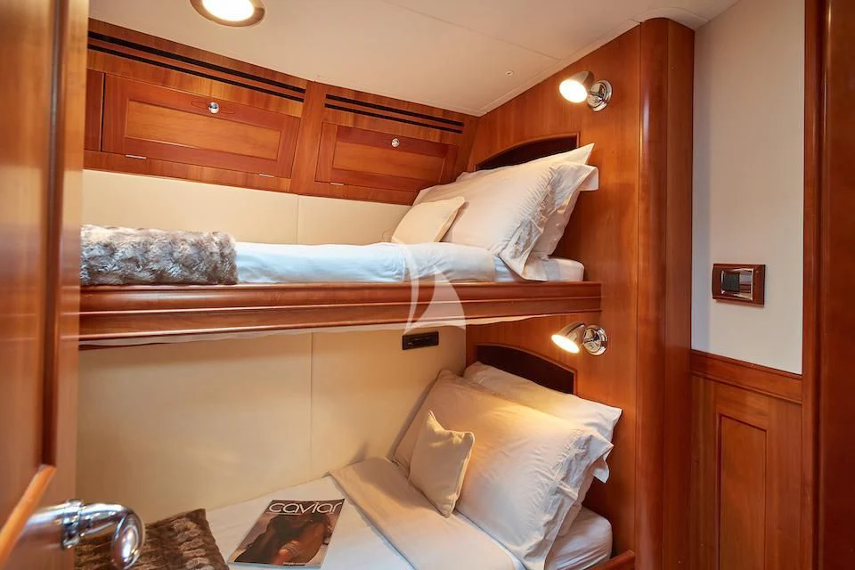 a bed with a wooden headboard aboard DARK STAR OF LONDON Yacht for Charter