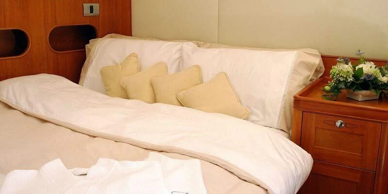 a bed with white sheets aboard DARK STAR OF LONDON Yacht for Charter