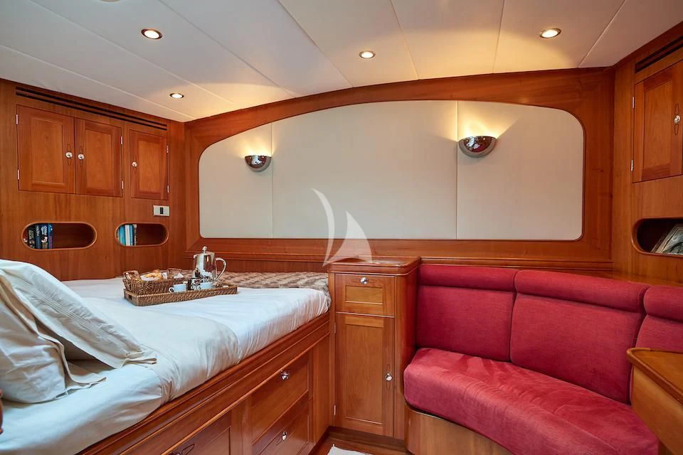 a bedroom with a bed and a couch aboard DARK STAR OF LONDON Yacht for Charter