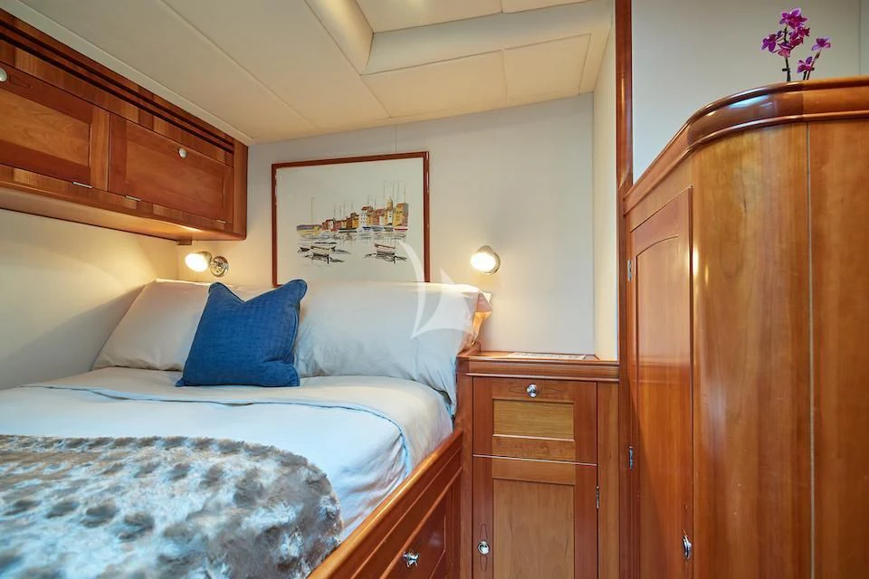 a bedroom with a bed and a dresser aboard DARK STAR OF LONDON Yacht for Charter