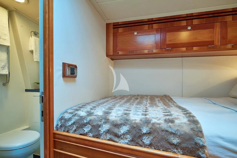 a bedroom with a bed and a dresser aboard DARK STAR OF LONDON Yacht for Charter