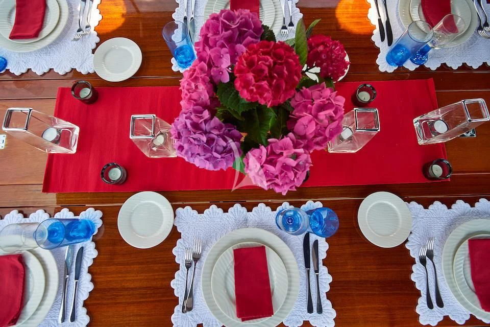 a table with plates and silverware aboard DARK STAR OF LONDON Yacht for Charter