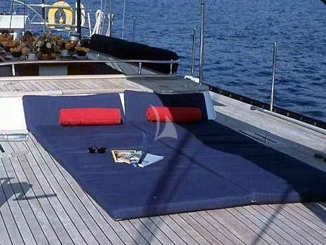 a deck with a pool and a boat in the water aboard DARK STAR OF LONDON Yacht for Charter