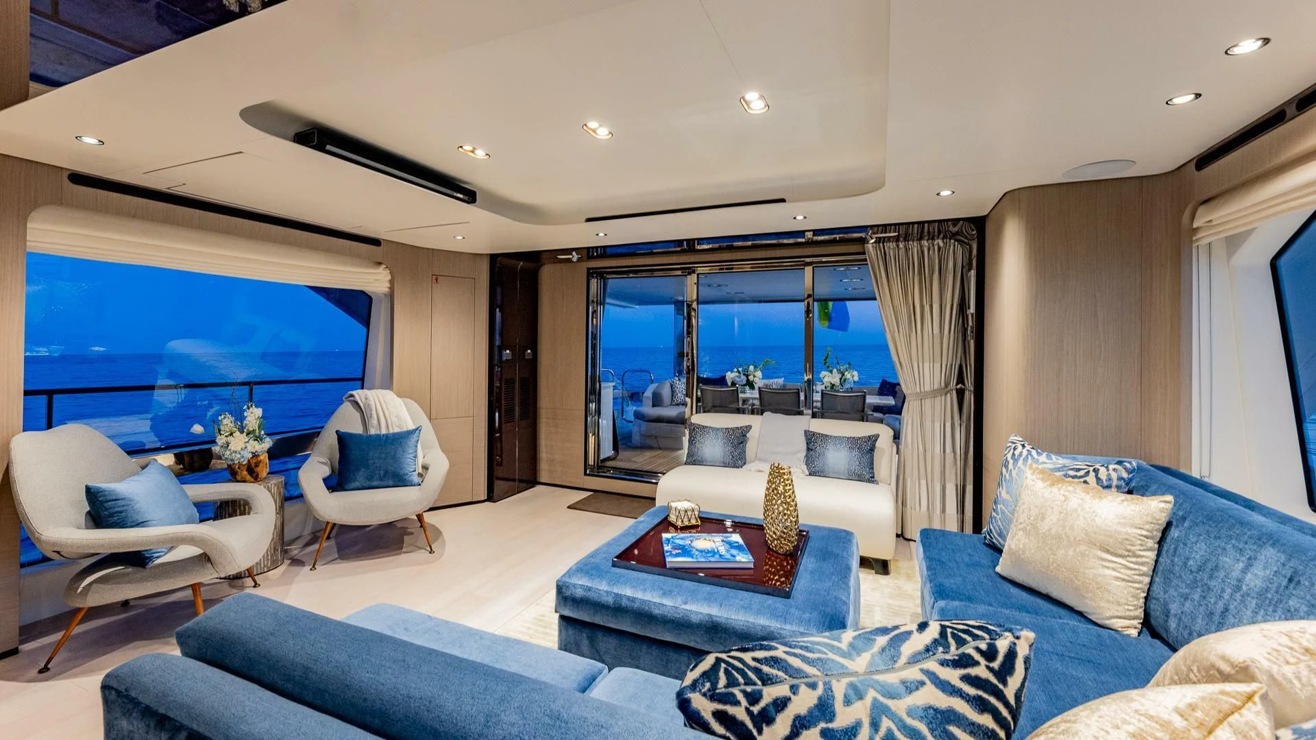 a living room with a large blue couch and a large window aboard CAPTAIN MORGAN II Yacht for Sale