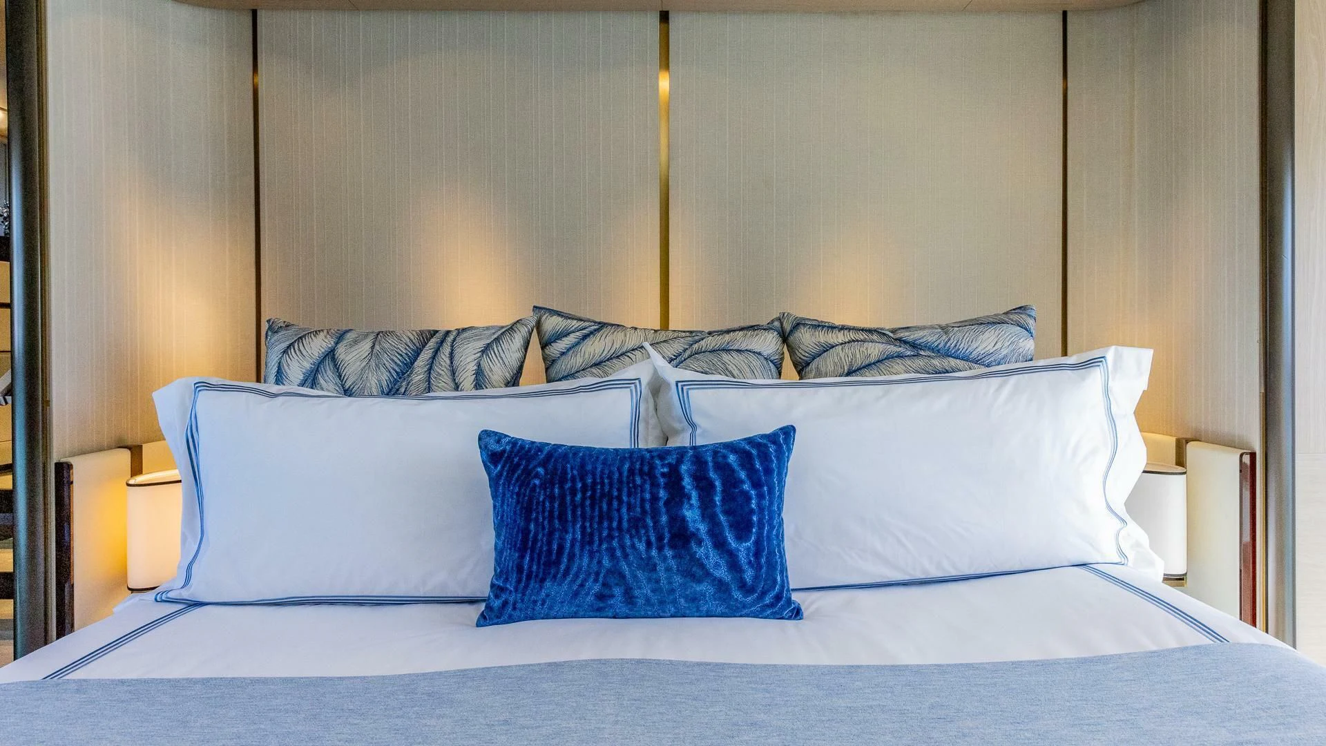 a bed with blue pillows aboard CAPTAIN MORGAN II Yacht for Sale