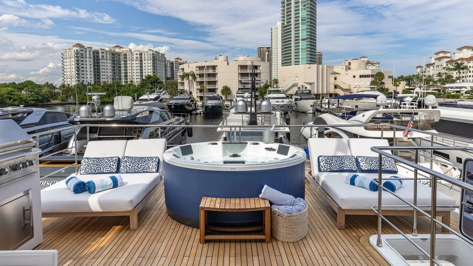 a boat dock with lounge chairs and a city in the background aboard CAPTAIN MORGAN II Yacht for Sale