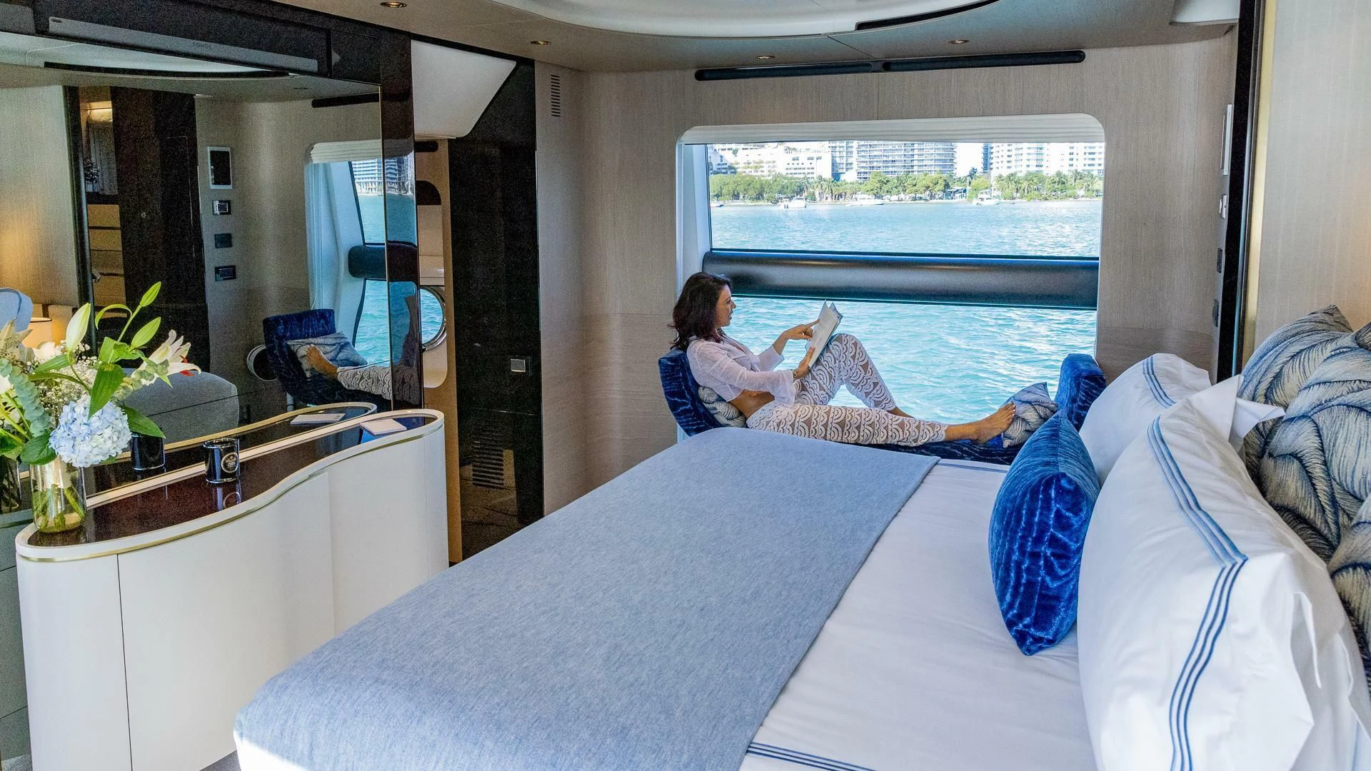 a couple of people sitting on a bed looking at a laptop aboard CAPTAIN MORGAN II Yacht for Sale