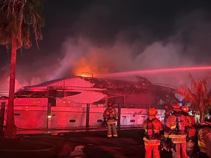 a group of firefighters standing next to a fire truck aboard SELF MADE Yacht for Sale