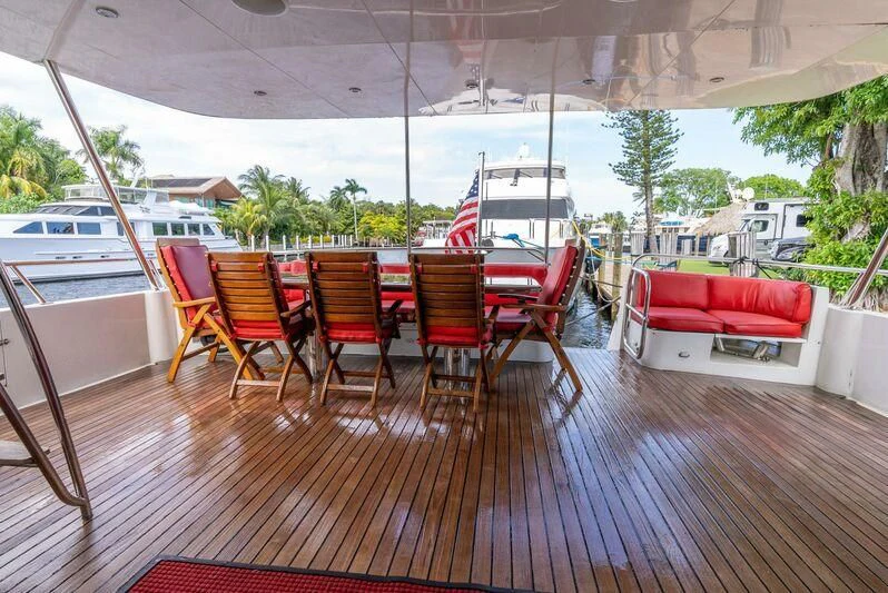 a deck with chairs and tables aboard SELF MADE Yacht for Sale