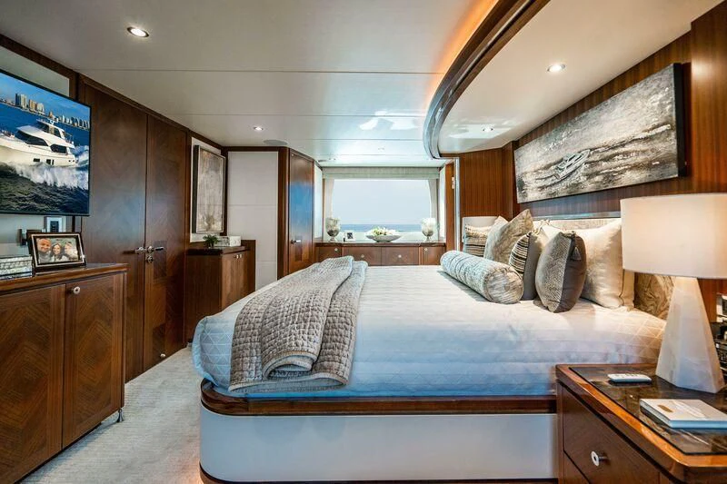 a bedroom with a bed and a desk aboard AURA Yacht for Sale