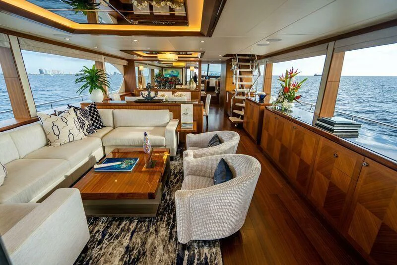a living room with a couch and a table aboard AURA Yacht for Sale