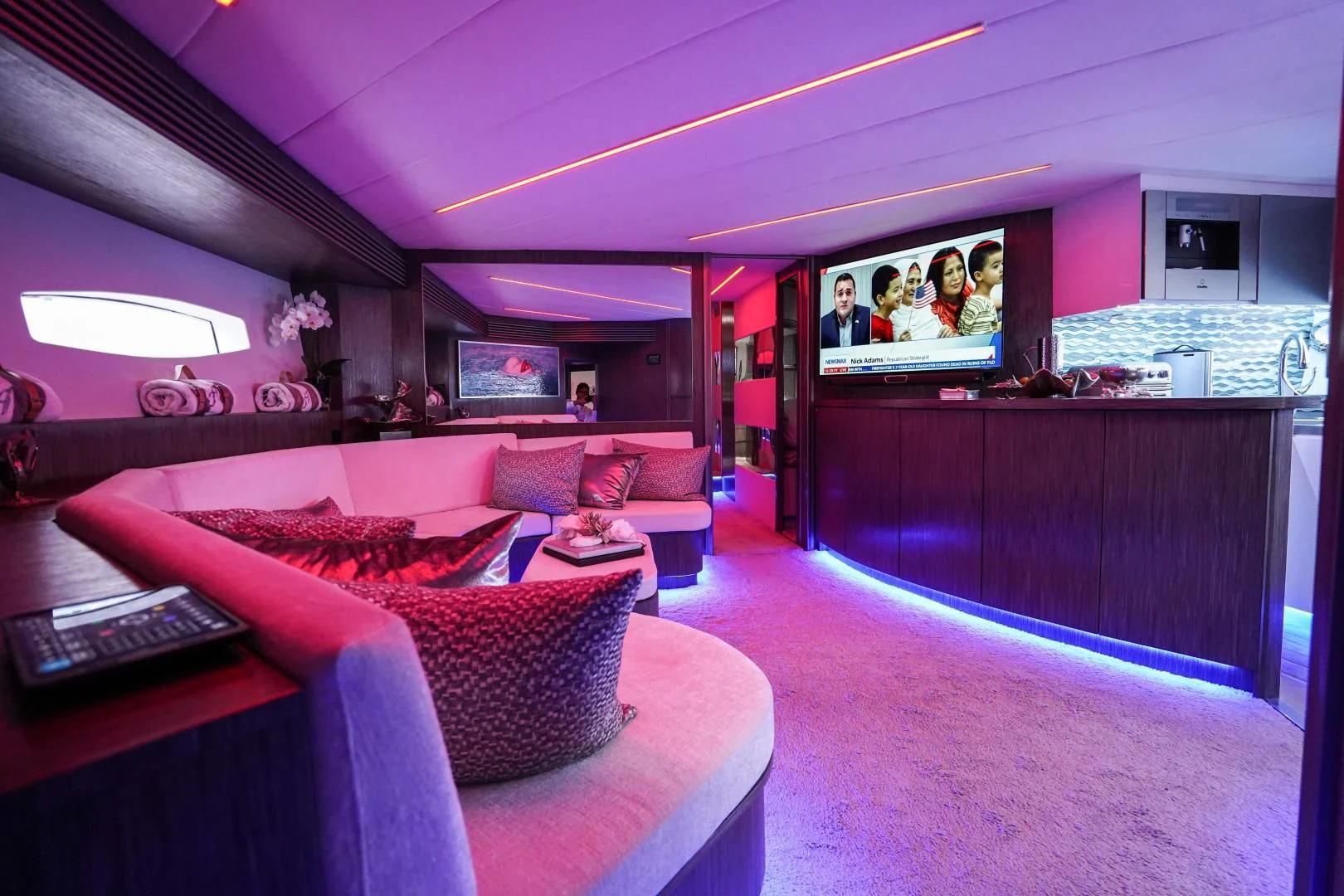 a living room with a tv and couches aboard AMORA Yacht for Sale