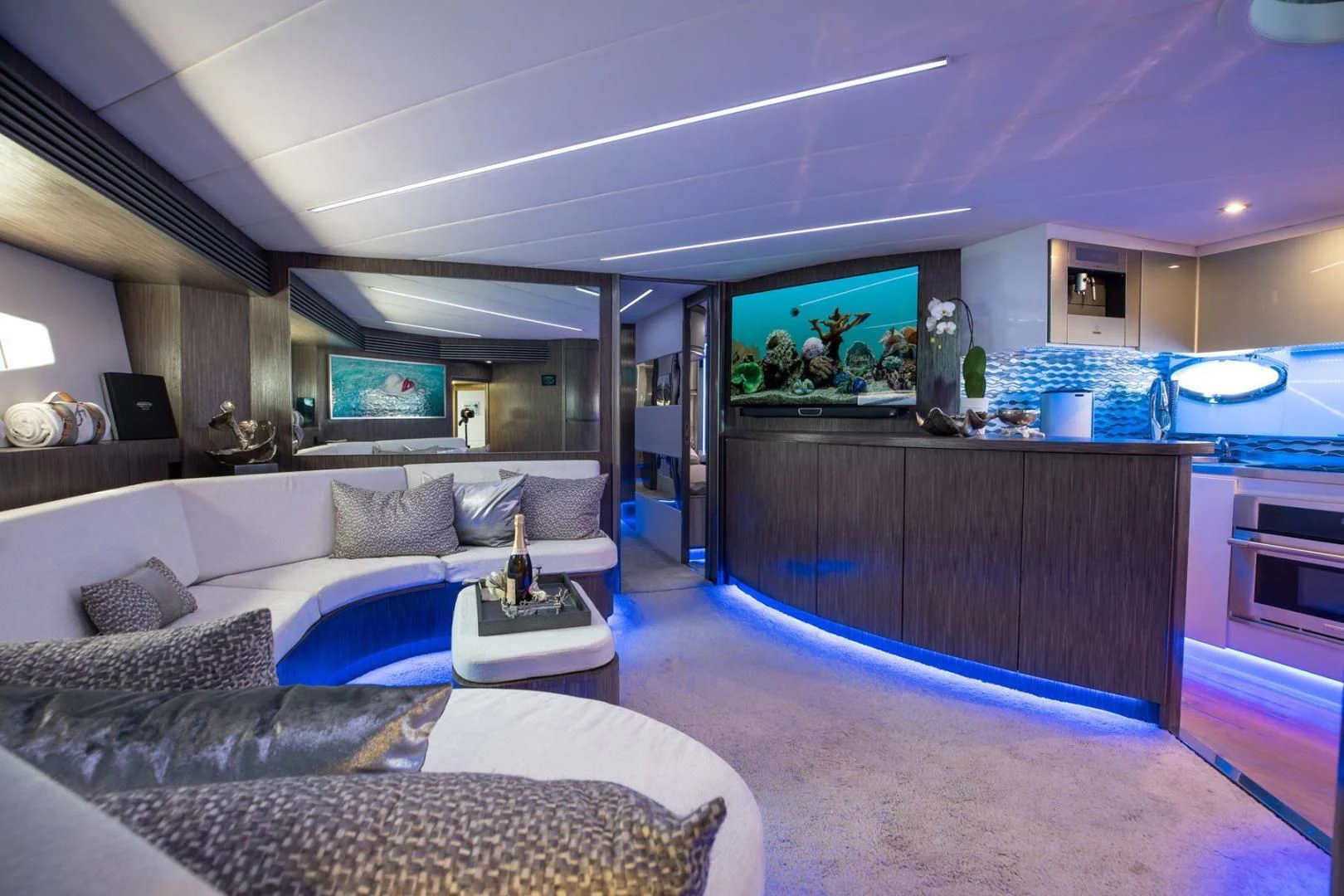 a living room with a large kitchen and a large mirror aboard AMORA Yacht for Sale
