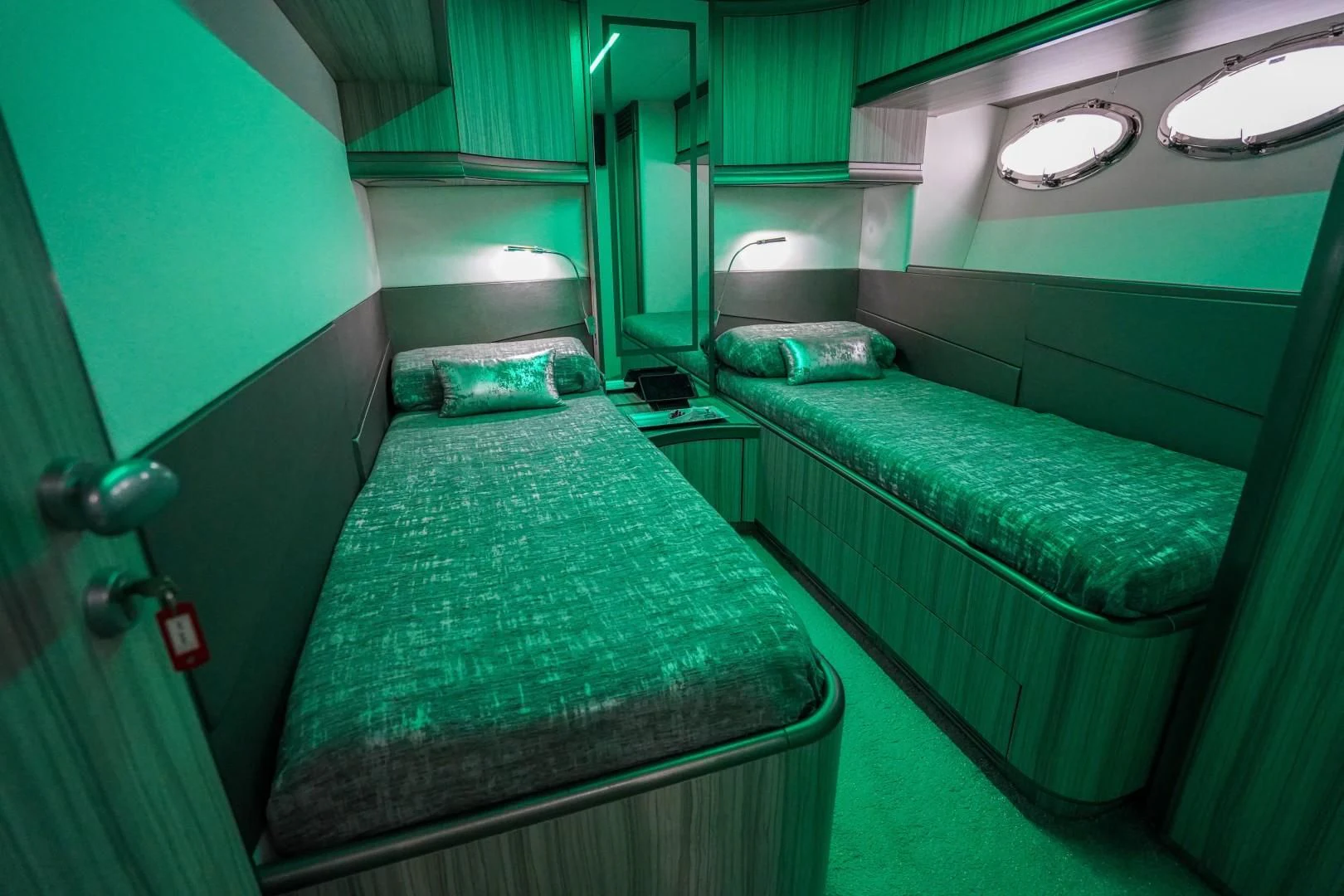 a room with green beds aboard AMORA Yacht for Sale