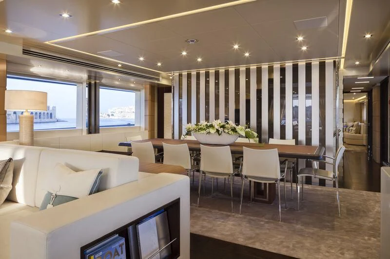 a room with a table chairs and a couch aboard AMORE MIO Yacht for Sale