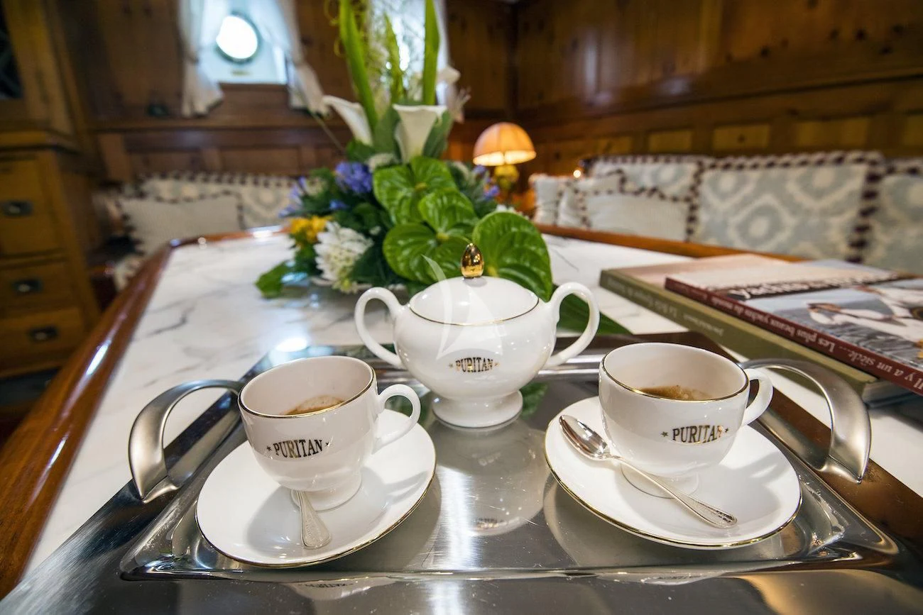 a table with a tea set and a plant on it aboard PURITAN Yacht for Sale