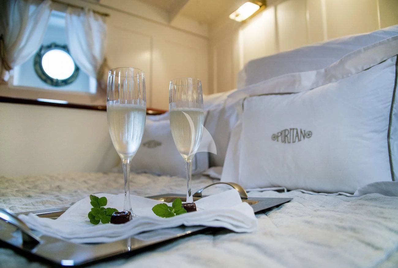 a couple of wine glasses on a table aboard PURITAN Yacht for Sale