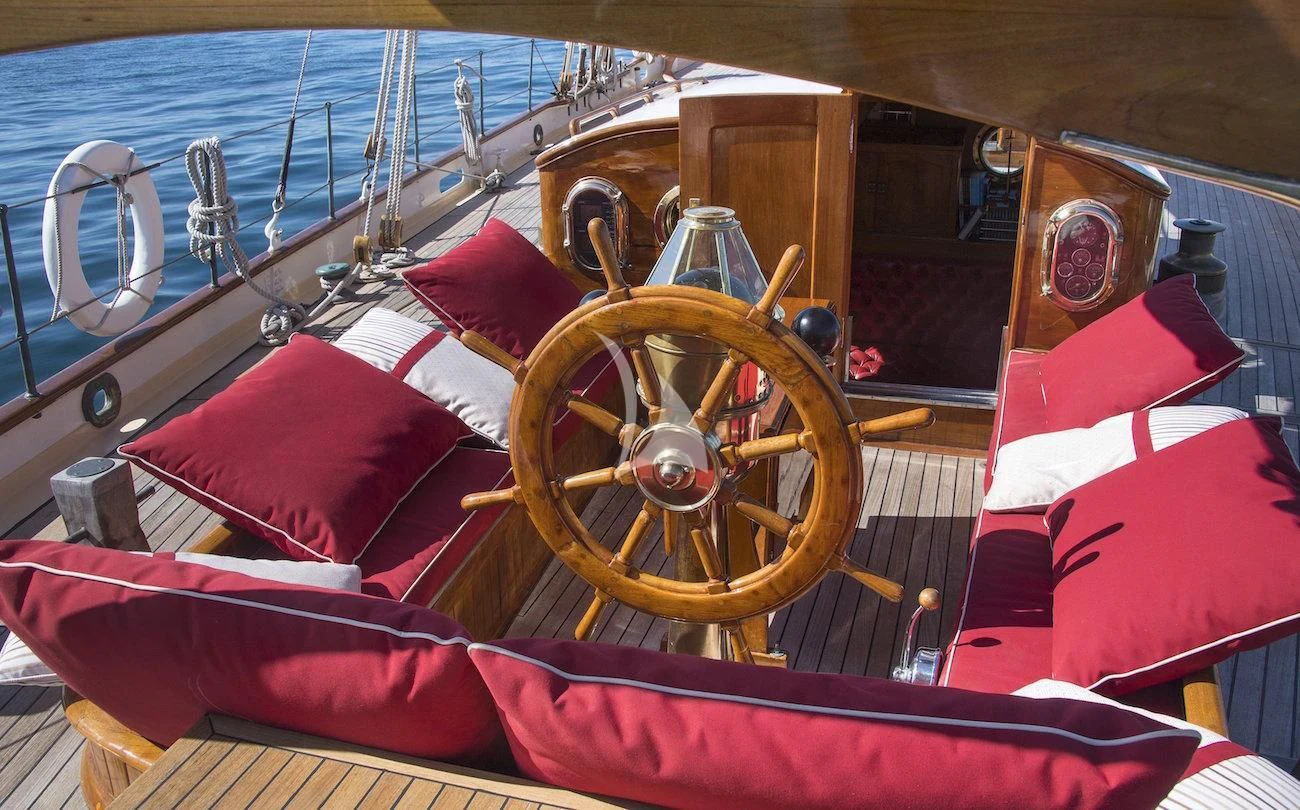 a wooden boat with a wooden steering wheel aboard PURITAN Yacht for Sale