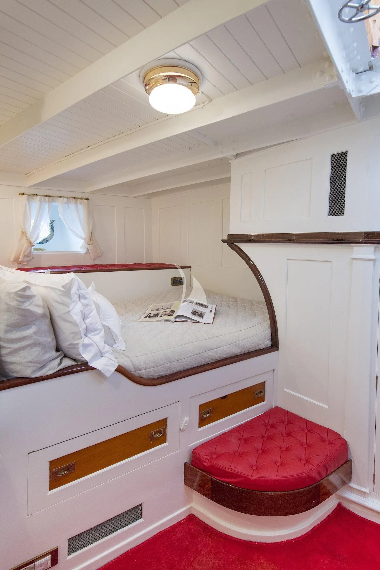 a small bedroom with a red chair aboard PURITAN Yacht for Sale