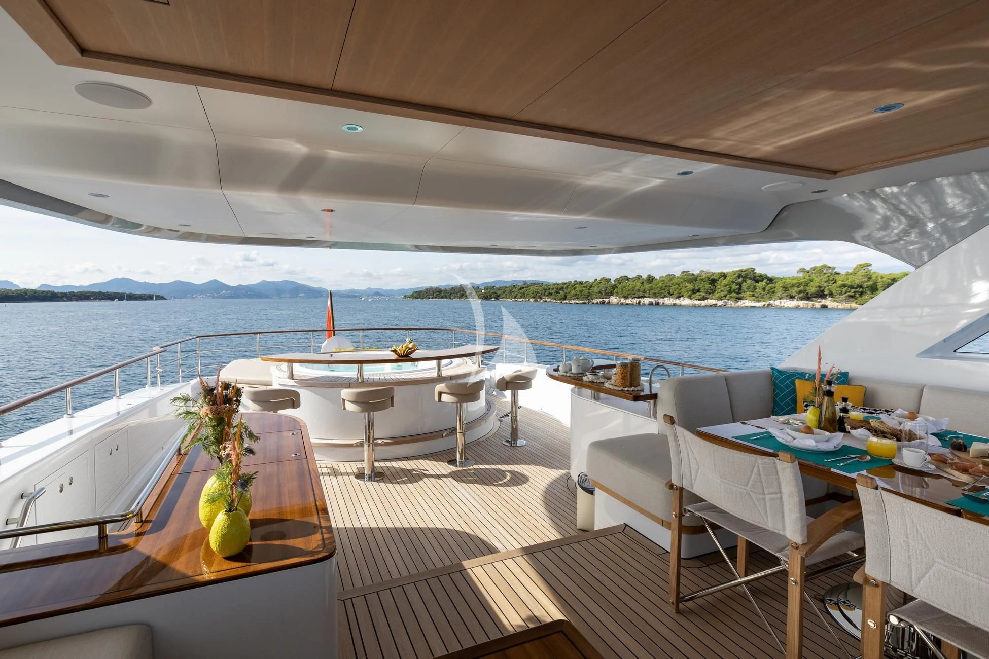 a room with a table and chairs on a deck overlooking a body of water aboard JOSEPHINE I Yacht for Sale