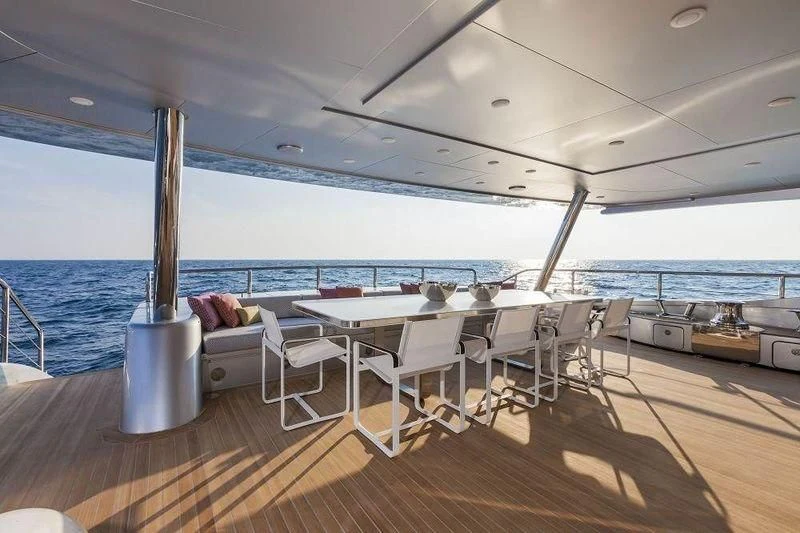 a deck with a table and chairs on it aboard PANTHERA Yacht for Sale