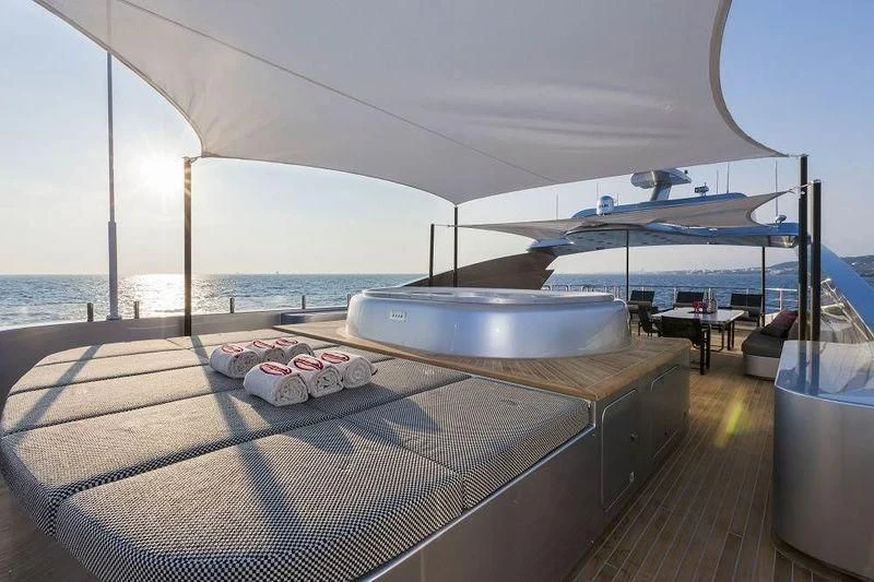 a large lounge area with a large swimming pool and a large deck with a large body of water aboard PANTHERA Yacht for Sale