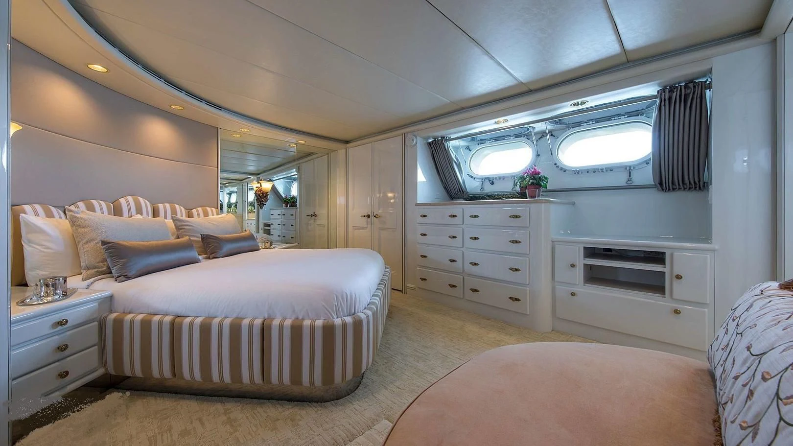 a bedroom with a bed and a large mirror aboard GRACE Yacht for Sale