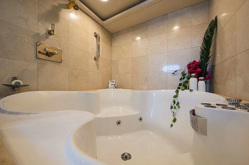 a bathroom with a bathtub and flowers aboard GRACE Yacht for Sale