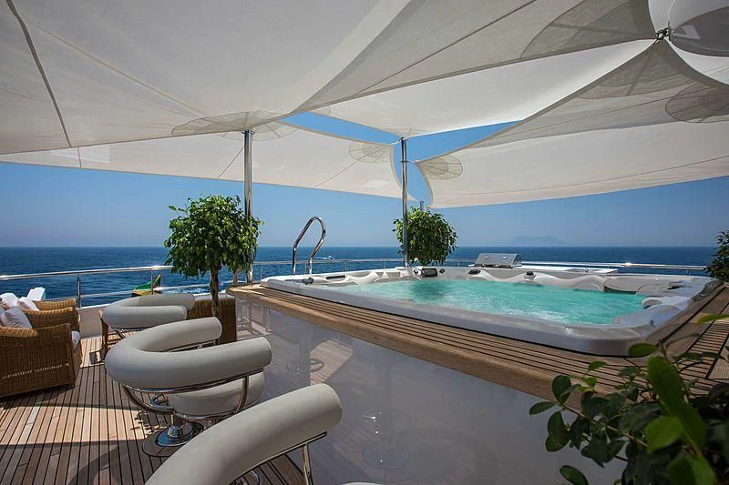 a large pool with a deck and chairs and a large body of water aboard GRACE Yacht for Sale