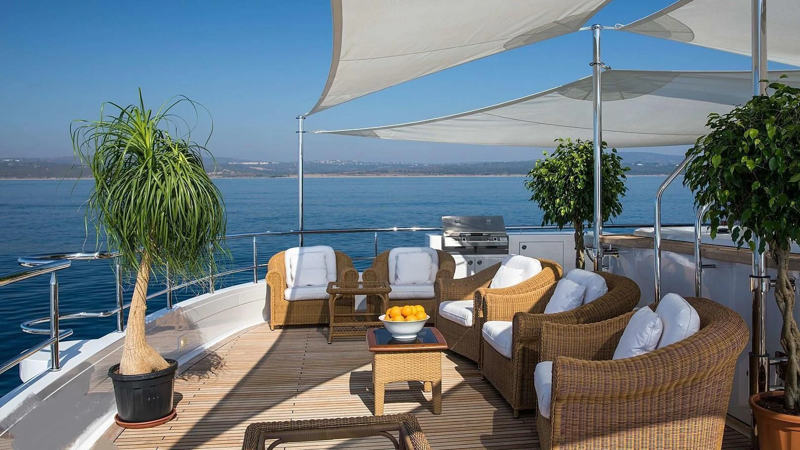 a patio with chairs and a table on it by the ocean aboard GRACE Yacht for Sale
