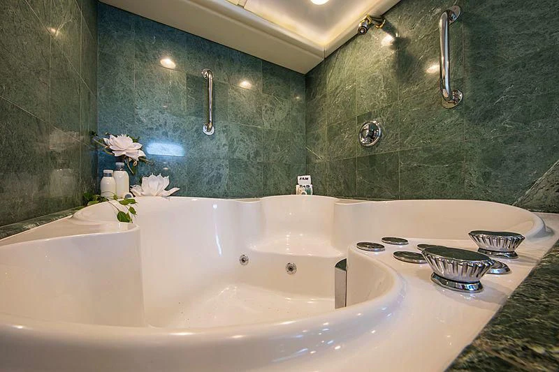 a bathroom with a tub sink and a mirror aboard GRACE Yacht for Sale