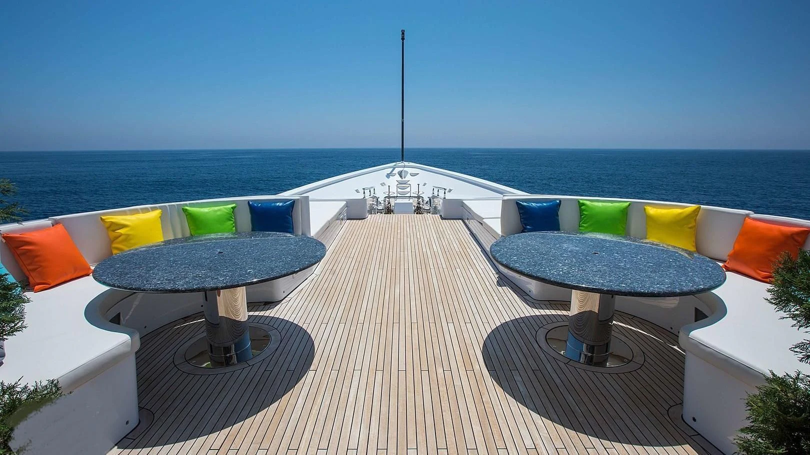 a table and chairs on a deck overlooking a beach aboard GRACE Yacht for Sale