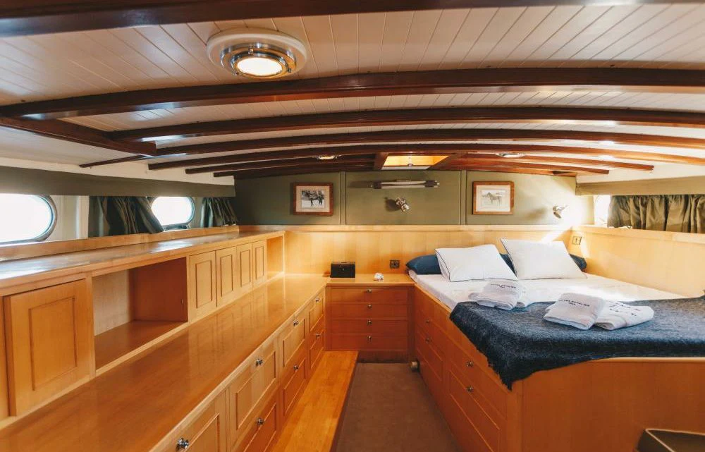 a room with a bed and a desk aboard SILVER CAVALIER Yacht for Sale