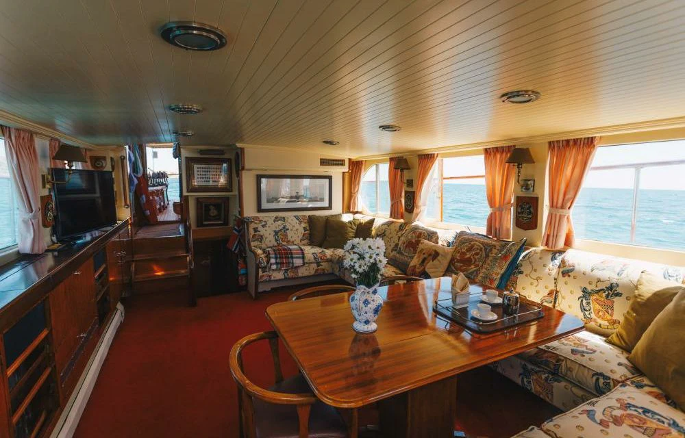 a living room with a table and couches aboard SILVER CAVALIER Yacht for Sale