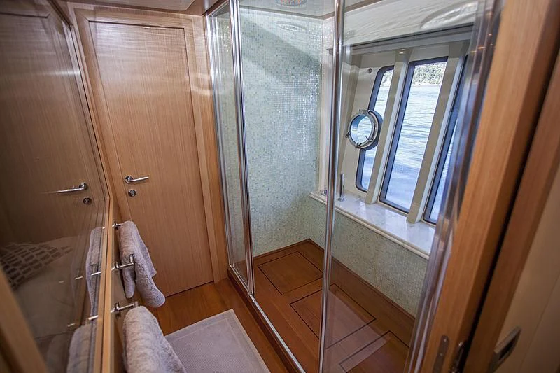 a bathroom with a glass shower door aboard YOYITA Yacht for Sale