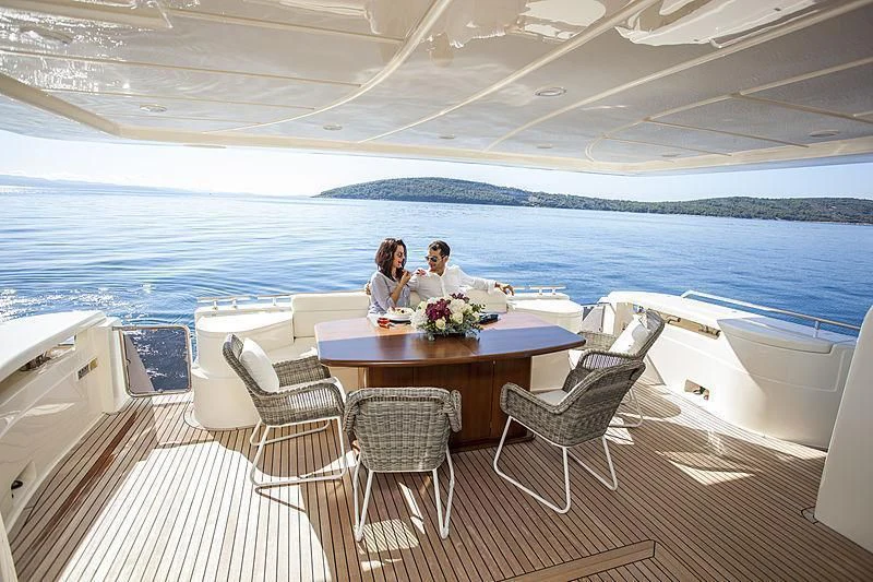 a couple sitting at a table on a boat aboard YOYITA Yacht for Sale