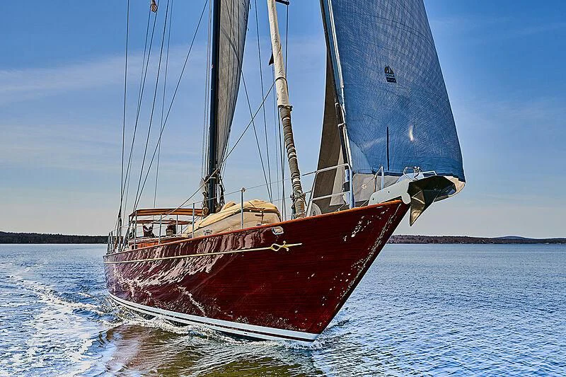 a red boat on the water aboard TEMPUS FUGIT Yacht for Sale