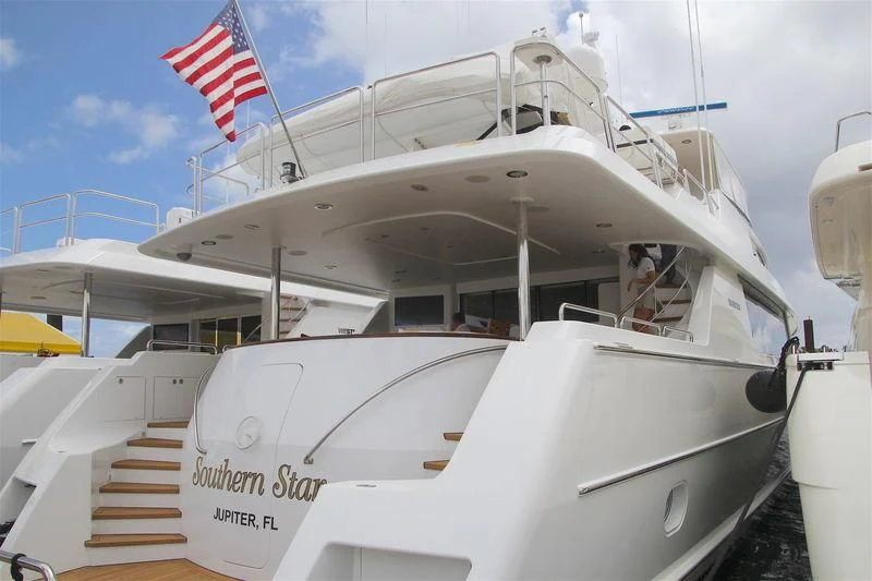 a boat with a flag on the front aboard LILA CUY Yacht for Sale