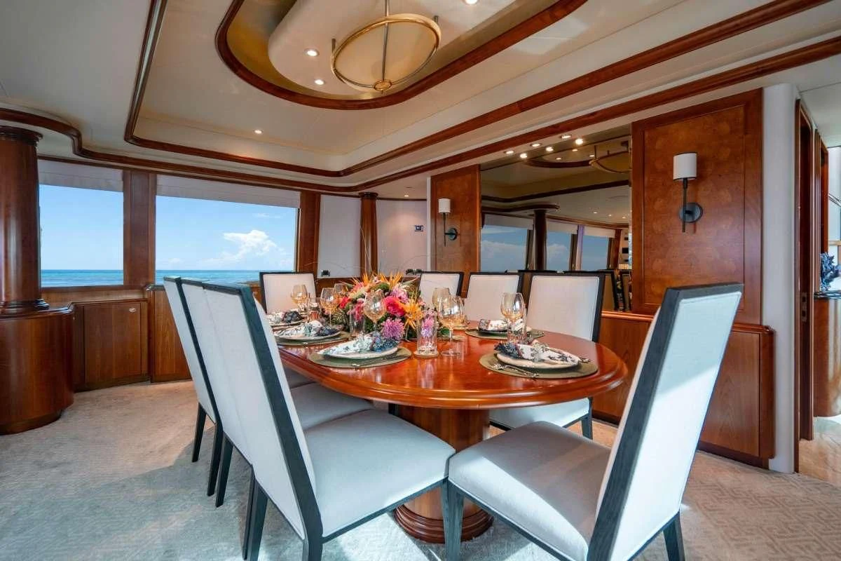 a dining table with chairs and a view of the ocean aboard LILA CUY Yacht for Sale