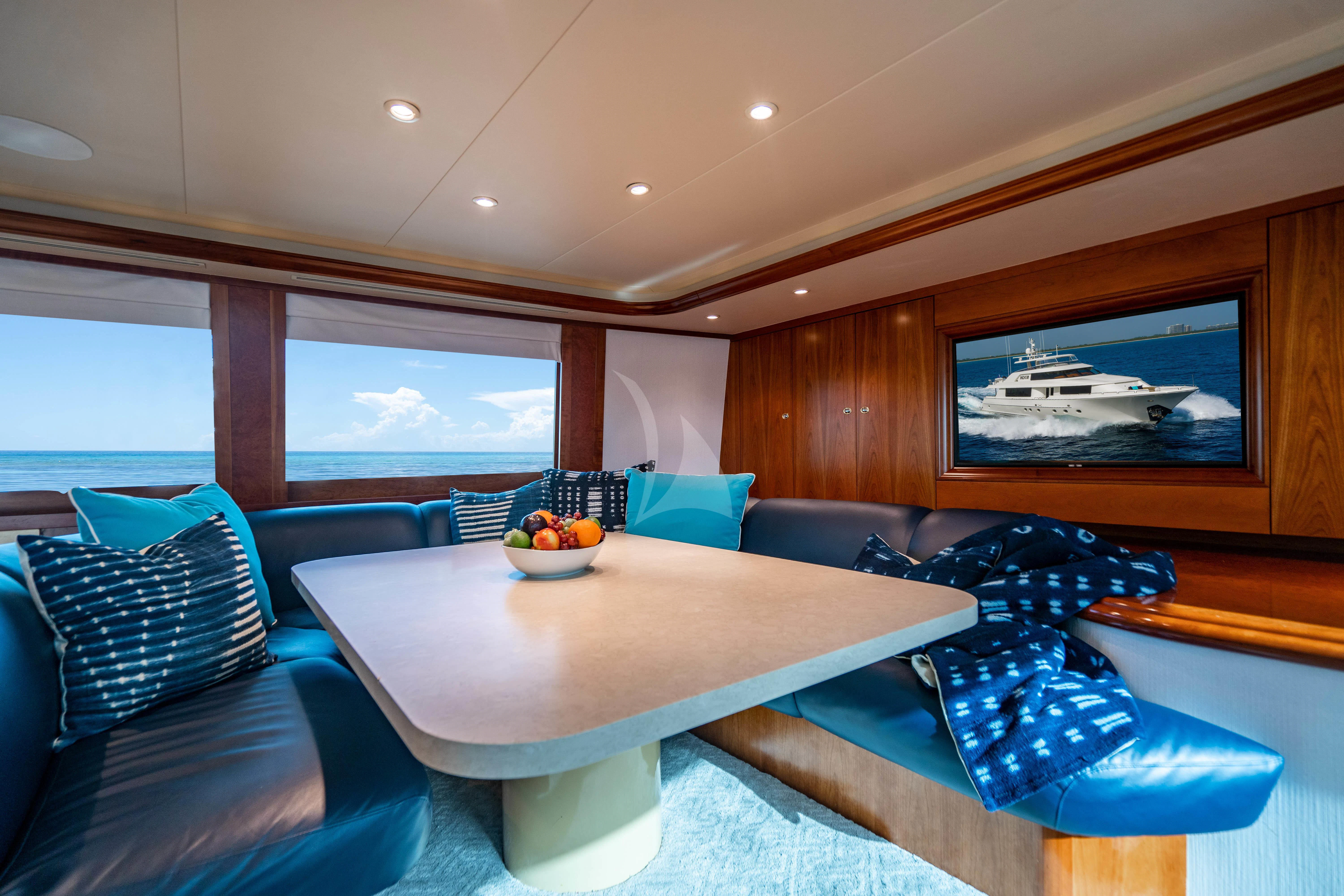 a room with a table and couch aboard LILA CUY Yacht for Sale