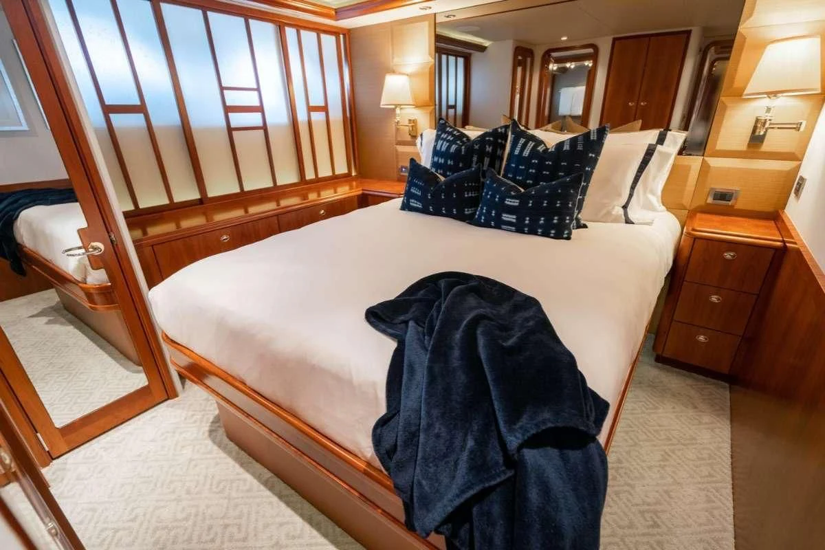 a bed with a blue blanket aboard LILA CUY Yacht for Sale