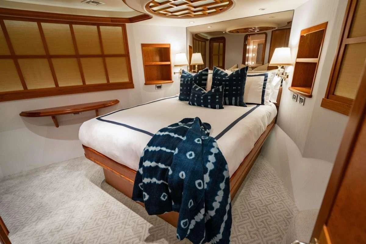 a bedroom with a bed and a table aboard LILA CUY Yacht for Sale