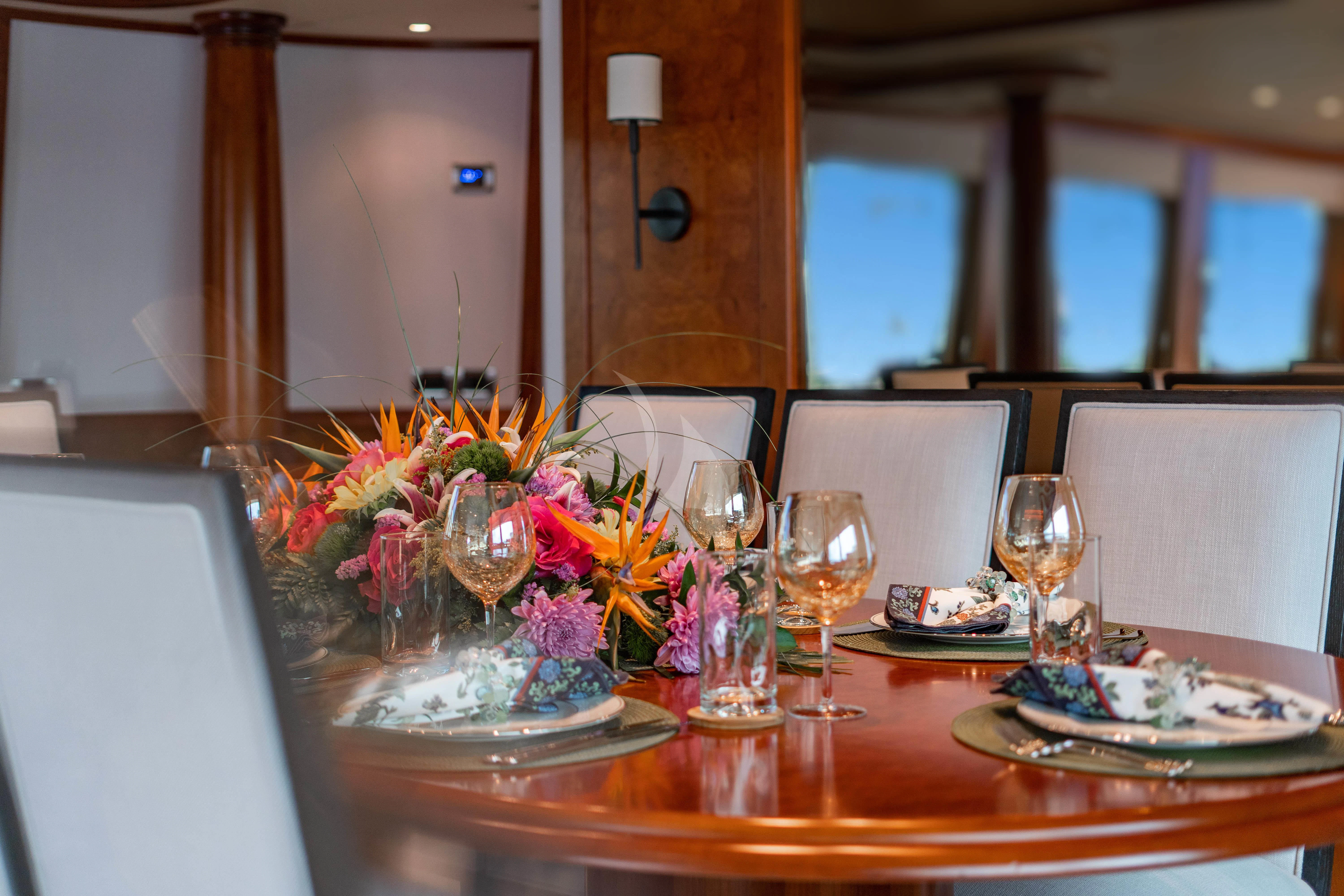 a table with flowers and candles aboard LILA CUY Yacht for Sale